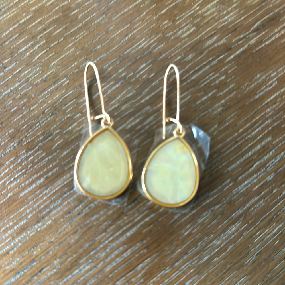 Cream colored earring with gold trim